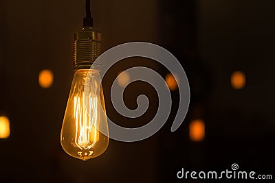 Glowing lightbulb dangling from the ceiling Stock Photo