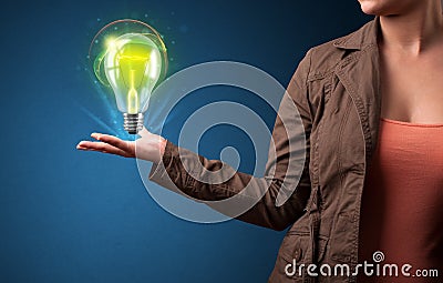 Glowing lightbulb in the hand of a woman Stock Photo