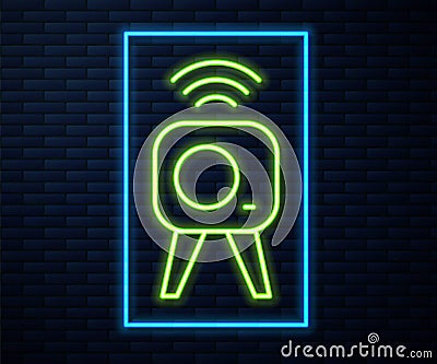 Glowing neon line Web camera icon isolated on brick wall background. Chat camera. Webcam icon. Vector Stock Photo