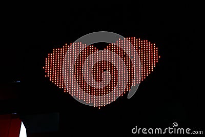 Glowing pixel red heart of LED lamps on black background Stock Photo