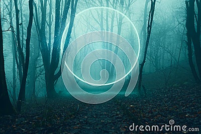 A glowing, portal, gateway floating above a track in a spooky misty winter forest, Science fiction concept Stock Photo
