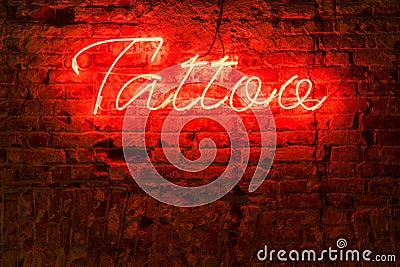 Glowing red neon signboard word tattoo Stock Photo