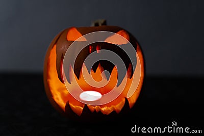 Glowing and terrified halloween pumpkin with a candle inside. Smiling Jack O` Lantern Stock Photo