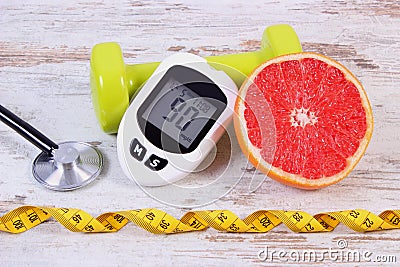 Glucometer, stethoscope, fresh grapefruit and dumbbells for fitness, diabetes, healthy lifestyles Stock Photo