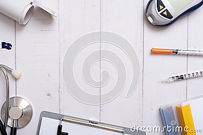 Glucometer, stethoscope and syringes with a tablet on a wooden background, top view. Copy space Stock Photo