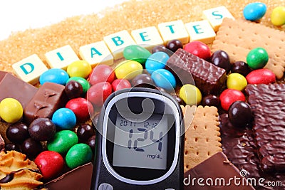 Glucometer, sweets and cane brown sugar with word diabetes, unhealthy food Stock Photo