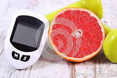 Glucometer for measuring sugar level, fresh grapefruit and dumbbells for fitness, healthy lifestyles concept Stock Photo