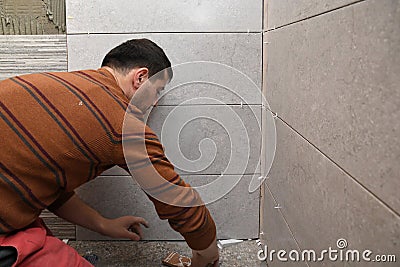 Gluing tiles on the wall. Laying tiles on the wall Stock Photo