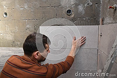 Gluing tiles on the wall. Laying tiles on the wall Stock Photo