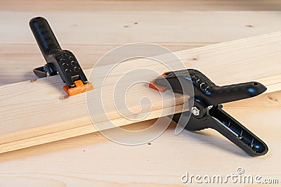 Gluing wood. Two plastic spring clamps joining two pieces of woo Stock Photo