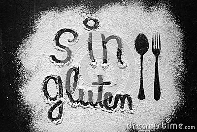 Gluten free flour with text gluten free in Spanish language with spoon and fork silhouette made with flour on dark texture Stock Photo