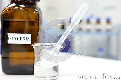 Glycerin in glass beaker and brown amber bottle inside laboratory with copy space. Stock Photo