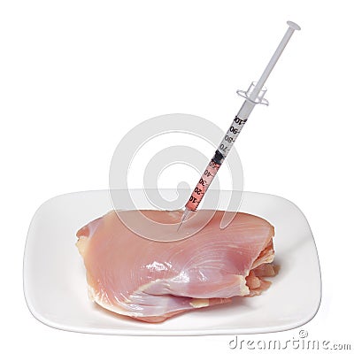 GMO food concept. Genetically modified raw chicken meat on square plate and syringe isolated on white. Genetic injectio Stock Photo