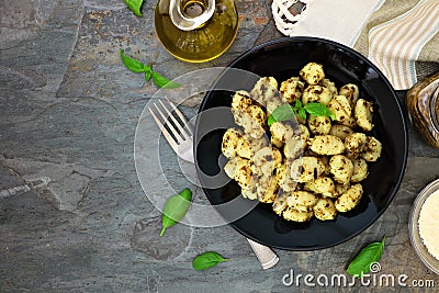 Gnocchi with pesto sauce, top view scene over dark stone Stock Photo