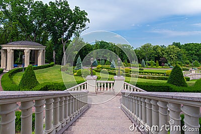 Go down to the alley of the park with crested green bushes and gazebo Stock Photo