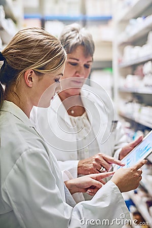 They go the extra mile. pharmacists using a digital tablet together. Stock Photo