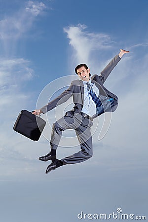 Go-getter. A young man carrying his briefcase and leaping into the air. Stock Photo