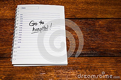 Go to hospital, handwriting text on page of office agenda. Copy space Stock Photo