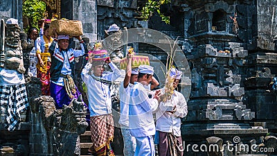 GOA LAWAH, BALI, INDONESIA - November 3, 2016: Balinese people in traditional clothes carry bless gift after ceremony at Editorial Stock Photo