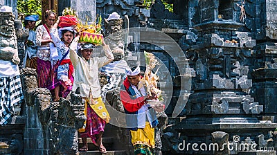 GOA LAWAH, BALI, INDONESIA - November 3, 2016: Balinese people in traditional clothes carry bless gift after ceremony at Editorial Stock Photo