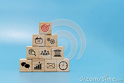 Goal. business finance icon on wooden cube block pyramid stack on blue background with copy space Stock Photo