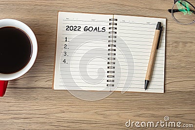 2022 GOAL with notebook, black coffee cup and pen on wood table, Top view and copy space. Happy New Year, Resolution, To do list, Stock Photo