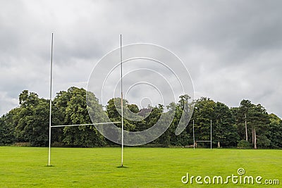 Goal posts on a rugby pitch surrounded by trees Stock Photo