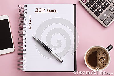 2019 goals list with notebook, cup of coffee over on pink background. Stock Photo