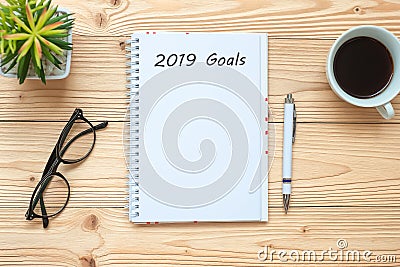 2019 Goals with notebook, black coffee cup, pen and glasses on table, Top view and copy space. New Year New Start, Resolution, Sol Stock Photo