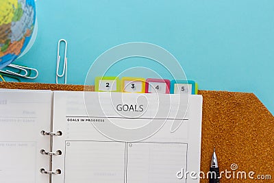 Goals setting on planner with mechanical pencil on blue background Stock Photo