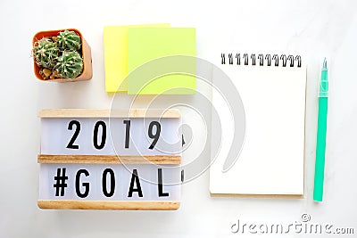 2019 goals on wood box and blank notebook paper on white marble Stock Photo