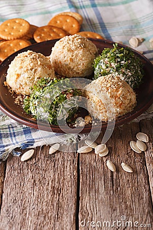 Goat Cheese balls with crackers, herbs and pumpkin seeds close-up. Vertical Stock Photo