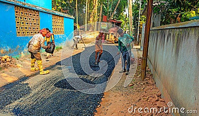 Male workers build road with asphalt Editorial Stock Photo