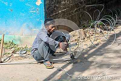 Man working with electrical wires without wearing safety gears Editorial Stock Photo