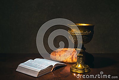 Goblet with wine bread and Holy Bible on a table Stock Photo