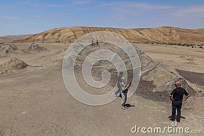 GOBUSTAN, AZERBAIJAN - JUNE 19, 2018: Tourists observe a mud volcano in Gobustan Qobustan , Azerbaij Editorial Stock Photo