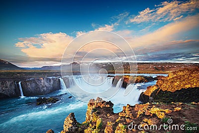 Godafoss waterfall at sunset. Fantastic landscape. Beautiful cumulus clouds. Iceland Stock Photo