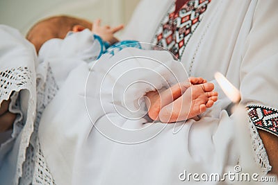 Godfather holds baby in church at sacrament of baptism. Stock Photo