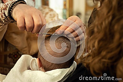 Godmother holds the baby the priest conducts a ceremony hair cut Stock Photo