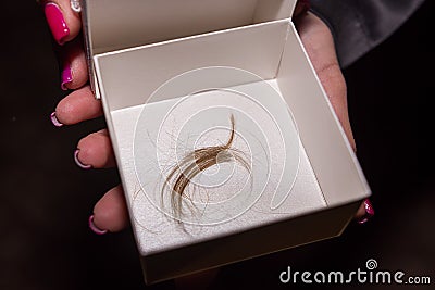 The Godmother holds little box with cut hair during the Christening Baptism ceremony at the church Stock Photo