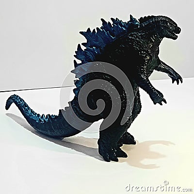Godzila toy with angry face with shadow and white background Editorial Stock Photo