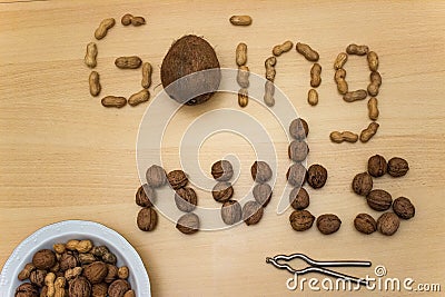 `Going nuts` with peanuts, walnuts, coconut, nut cracker and plate Stock Photo