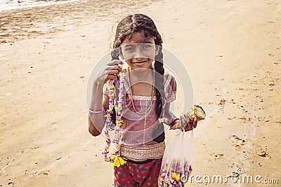 Little girl selling natural blossom necklaces on the Kudli Beach Editorial Stock Photo