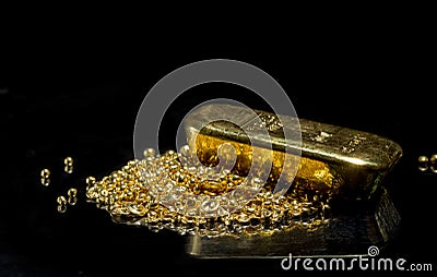 Gold bar on a pile of gold granules. Stock Photo