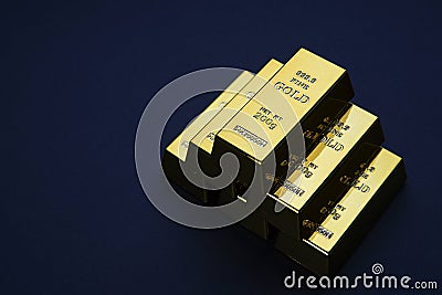 Gold bars stacked in a pyramid shape. Shiny precious metals for investments or reserves. Stock Photo