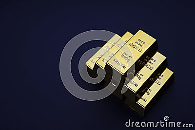 Gold bars stacked in a pyramid shape. Shiny precious metals for investments or reserves. Stock Photo