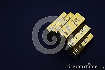 Gold bars stacked in a pyramid shape. Shiny precious metals for investments or reserves. Stock Photo