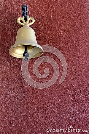 A gold bell on a red painted wall Stock Photo