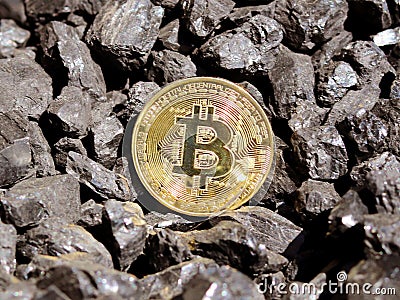 Gold bitcoin on a coal`s background. Mayerized Crypto currency. Payroll through the Internet. To drip crypto currency bitcoin. The Stock Photo