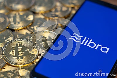 Bitcoin Coin with the Facebook`s Libra Crypto Coin logo Editorial Stock Photo